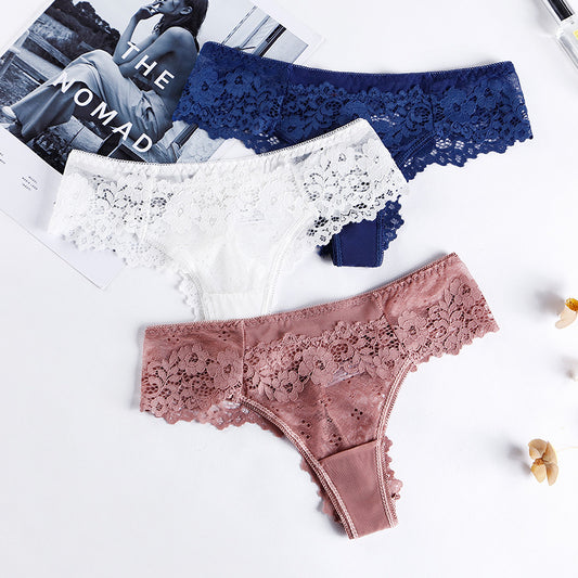 Flat lay of navy, white, and rose lace-trimmed panties on light background