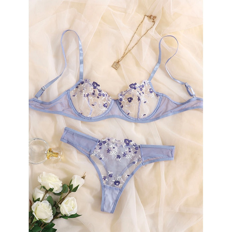 Lavender floral lace lingerie set with embroidered flowers displayed on soft fabric.