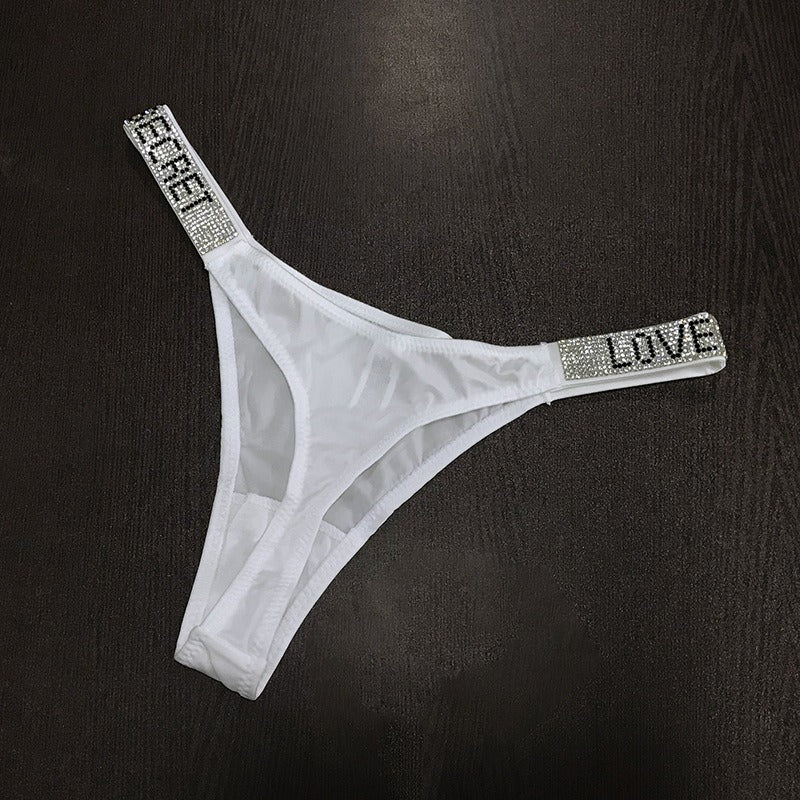 White thong with rhinestone straps featuring the words LOVE and SECRET
