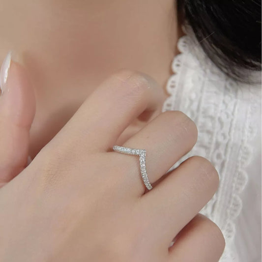 Close-up of V-shaped silver ring with small diamonds worn on hand